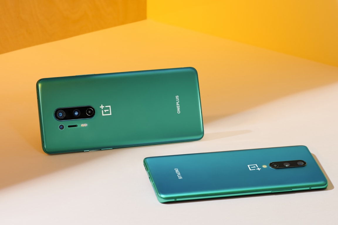 Two sleek and shiny green OnePlus smartphones with curved displays and multiple cameras.